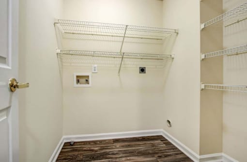 A room with a white door and a white wall with a shelf on the wall.