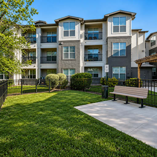 Apartment complex with a bench in front of it.