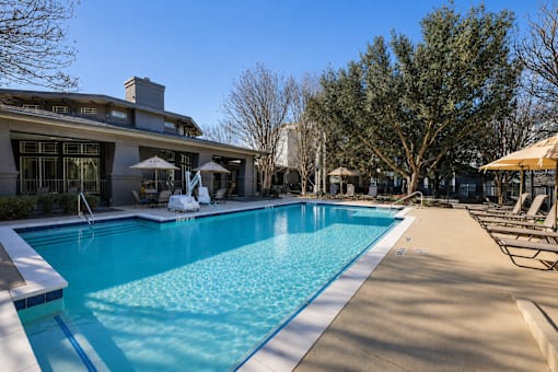 A large swimming pool with a blue tinted water and a white line around it.