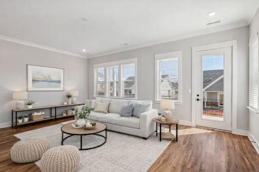 A living room with a white couch, a coffee table, and a painting on the wall.