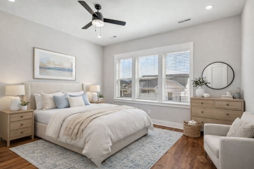 A bedroom with a large bed, a ceiling fan, and a painting on the wall.