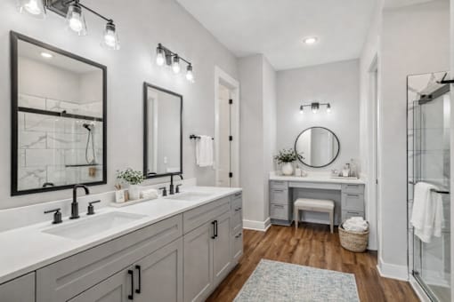 A bathroom with two sinks and a round mirror.
