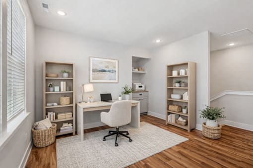 A home office with a desk, chair, and shelves.