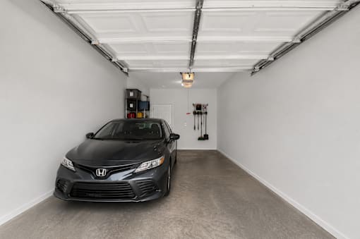 A black Honda Civic is parked in a garage.