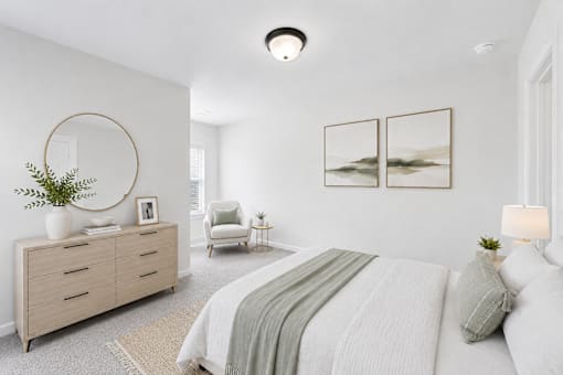 A bedroom with a bed, a chair, a dresser, and two pictures on the wall.