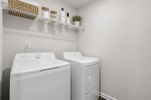 A white washing machine and dryer in a small laundry room.