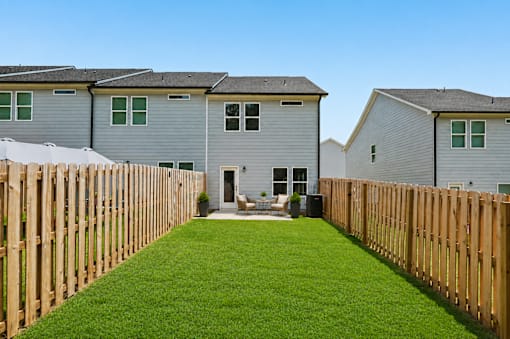 A row of houses with a green lawn in front.