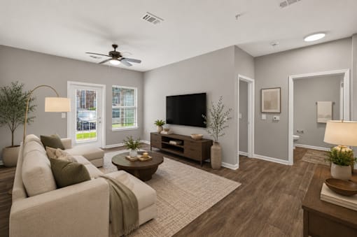 A living room with a couch, a coffee table, a television, and a ceiling fan.
