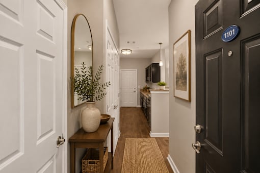A hallway with a black door on the right and a white door on the left.