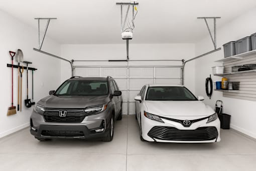 Two cars are parked in a garage.