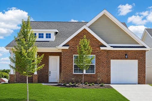 A house with a white garage door and a brick facade.