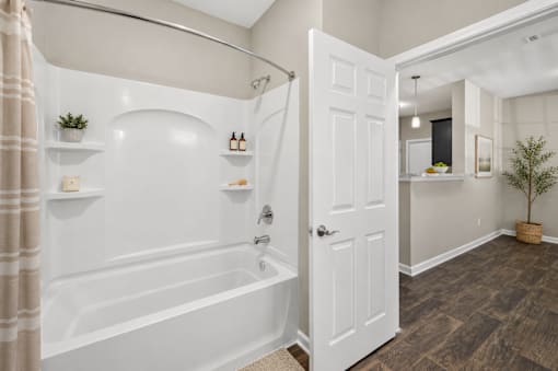 A bathroom with a white bathtub and a white door.