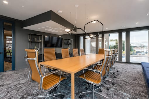 A conference room with a long table and chairs.