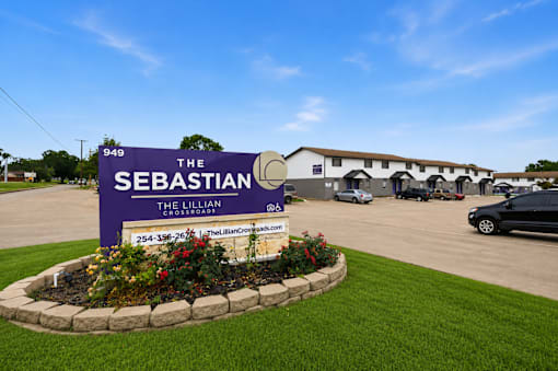 A sign for The Sebastian Lillian Crossroad with a phone number on it.