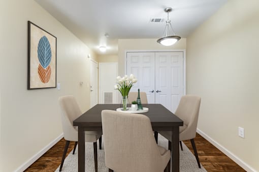 A dining room with a table and chairs.