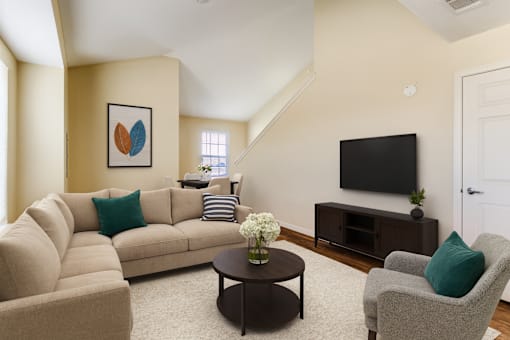 A living room with a beige couch, a coffee table, and a television.