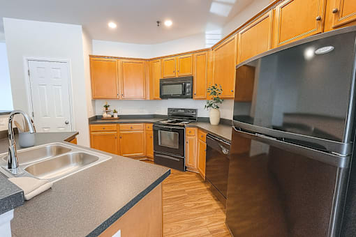 A kitchen with wooden cabinets and black appliances.
