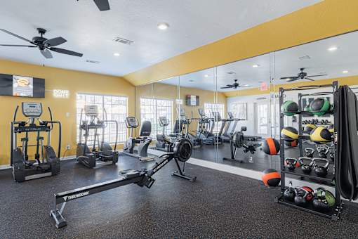 A gym with a variety of equipment including weights and a treadmill.