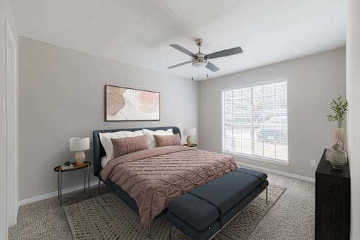 A bedroom with a bed, nightstand, and a painting on the wall.
