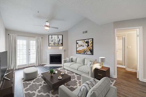 A living room with a fireplace, a grey couch, and a painting on the wall.