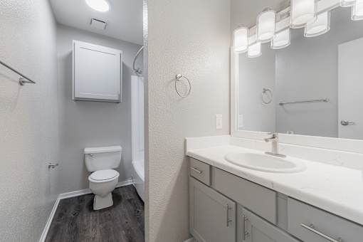 A white toilet sits in a small bathroom next to a sink.