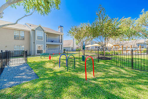 A playground with a red pole in the foreground and a building in the background.