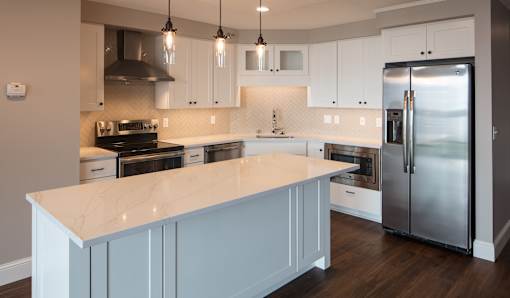 A kitchen with a marble countertop and stainless steel appliances.
