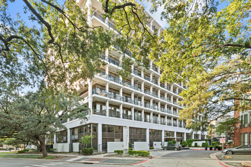an apartment building on a city street with trees