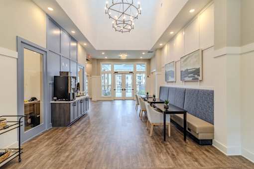 A spacious living room with a television, a dining table, and a bench.