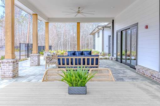 A patio with a blue couch and a plant in a pot.