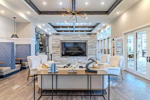 A modern living room with a stone fireplace and a large coffee table.