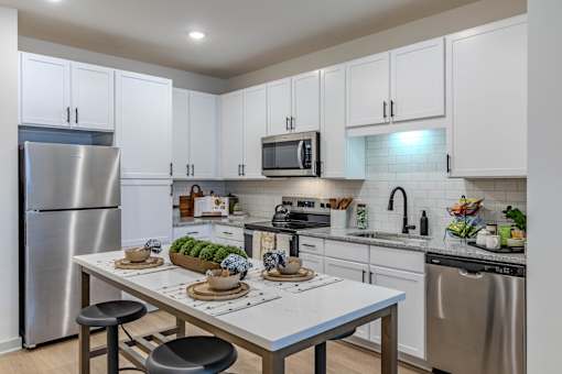 A modern kitchen with a table set for two.