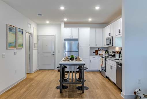 A modern kitchen with a table set for two.