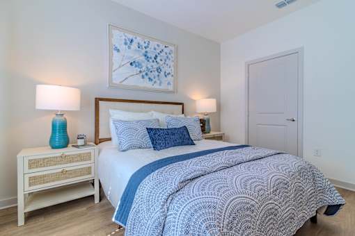 A bedroom with a bed, nightstand, and two lamps.
