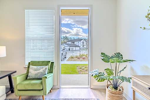 A room with a green chair and a potted plant.