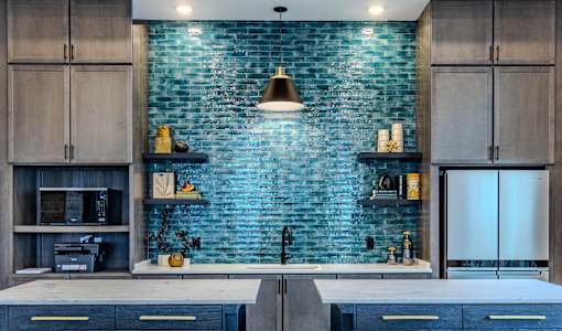 A kitchen with a blue brick wall and wooden cabinets.