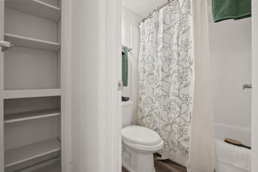 A white toilet in a bathroom with a shower curtain.