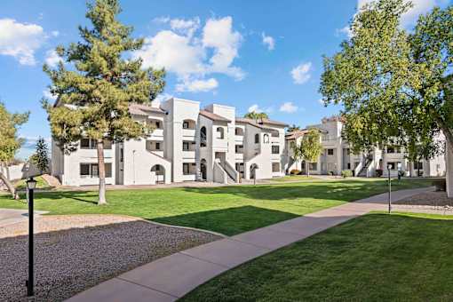 A white building with a green lawn in front.