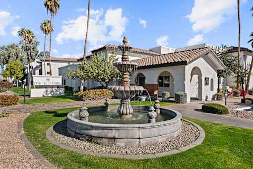 A fountain in front of a building with a sign that says "The Clifford".