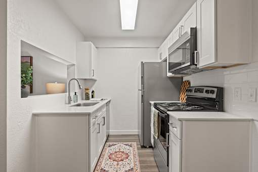 A kitchen with white cabinets and a black stove top oven.