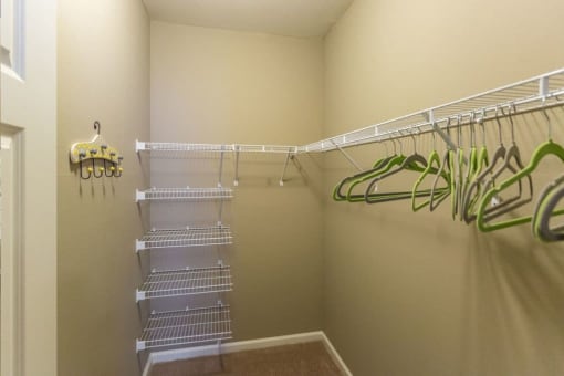 a walk in closet with shelves and a mirrored closet door