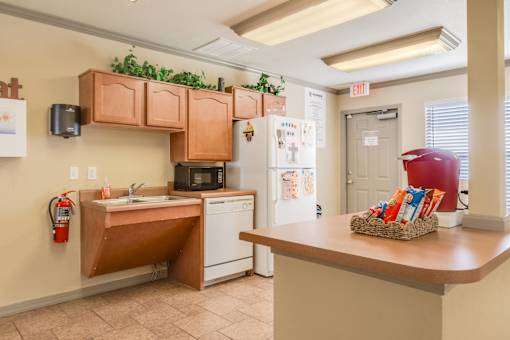 A kitchen with a red kettle on the counter.