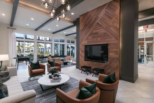 A modern living room with a wooden accent wall and a flat screen TV.