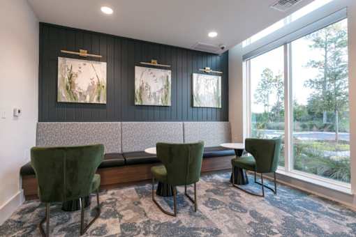 A room with a bench and chairs and pictures on the wall.