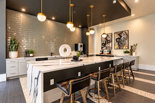 A kitchen with a long island and chairs.