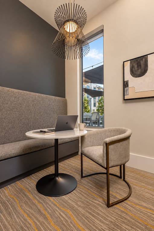 A modern chair with a laptop on a table in a room.