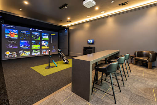 A room with a bar and a screen showing different images.