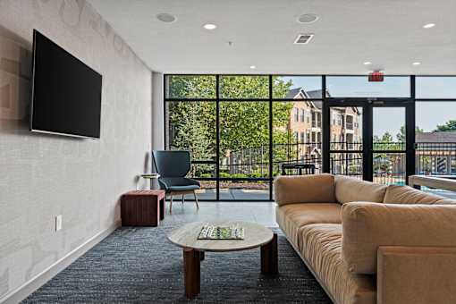 A living room with a flat screen TV mounted on the wall.