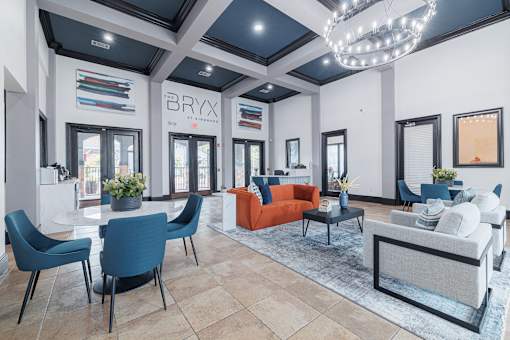 A modern living room with a white sofa and blue chairs.