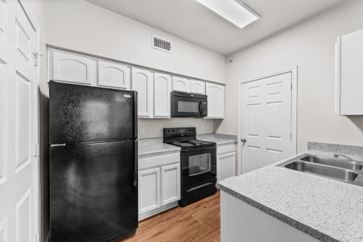 the preserve at ballantyne commons apartment kitchen with black appliances and white cabinets